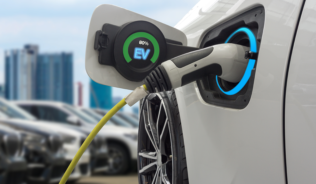 A white electric car being charged